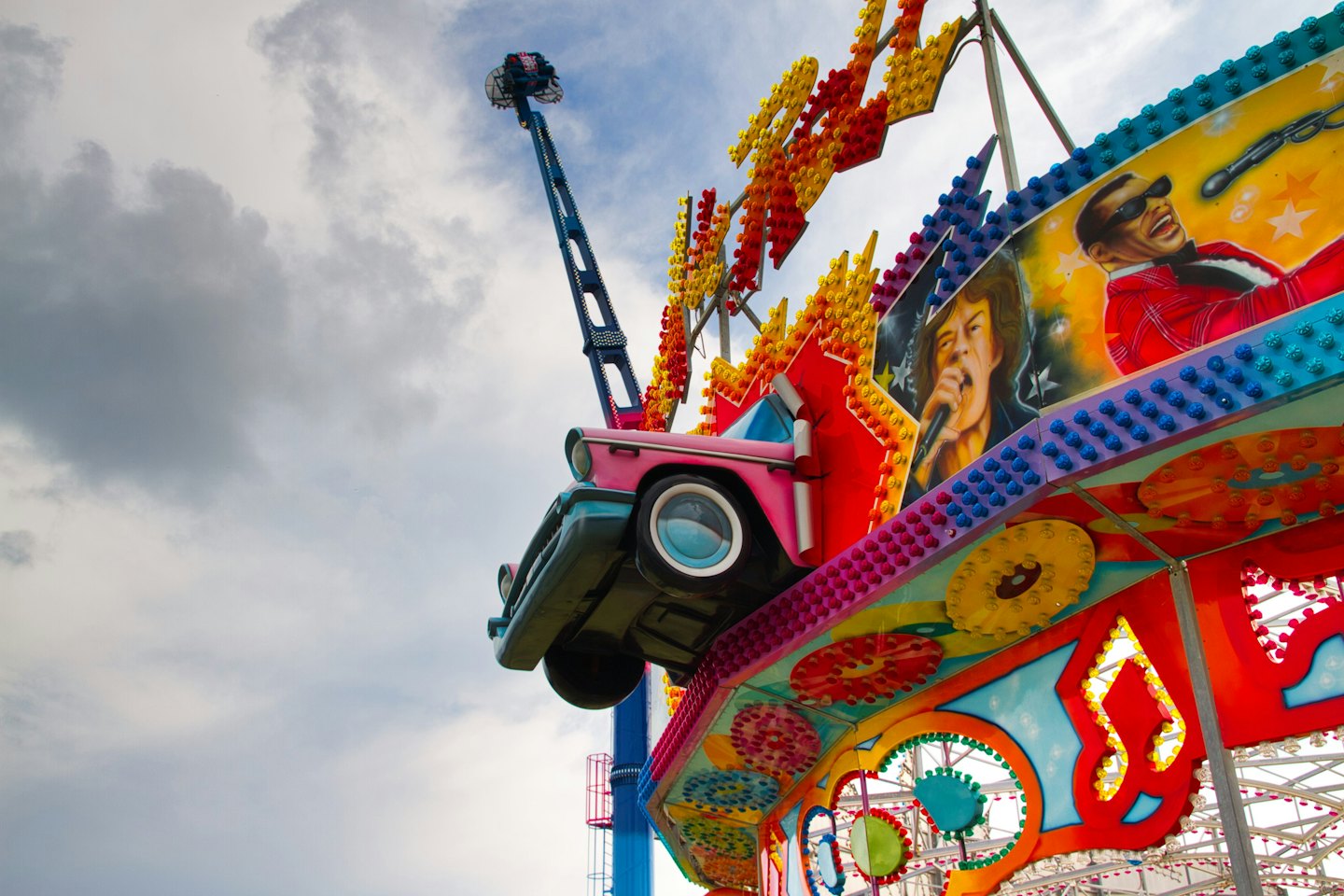 Colorful carnival ride with retro car facade at an amusement park.